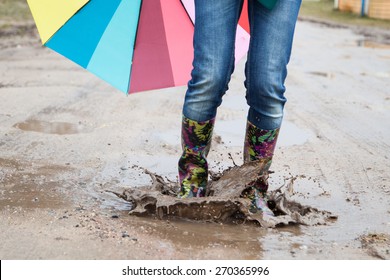 Woman In Rain Boots Jumps Into A Puddle