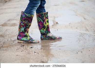 Woman In Rain Boots Jumps Into A Puddle