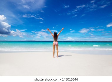 woman with raised hands on the beach