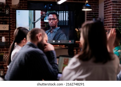 Woman Raising Hand To Ask A Question While Discussing With Remote Manager During Online Video Call Conference Late At Night. Mixed Team Working Overtime Greeting Business Owner In Internet Meeting.