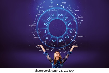 Woman raising hands looking at the night sky. Astrological wheel projection