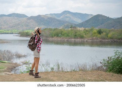 Woman Raising Hands Up On The Banks Of The Lake  Asian Woman Hiker In Front Smiling Happy, Woman Hiking In Woods, Warm Summer Day.