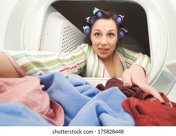 A Woman Reaching In The Dryer For Clothes