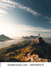 Woman reaching peak of mountain during sunset. Enjoying feeling after reaching mountain peak in Lofoten island in norway. - Shutterstock ID 1641960175