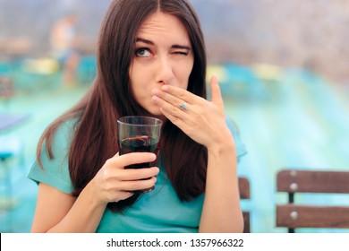 Woman Reacting after Having a Fizzy Soda Drink. Funny female customer in a restaurant having a carbonated beverage