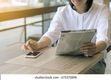 Woman Read Newspaper And Check Update News From Phone.