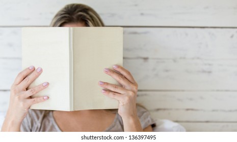 Woman Reading A Book And Covering Her Face