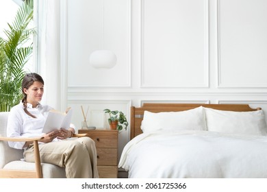 Woman Reading A Book In Her Bedroom