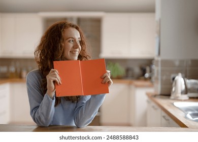 Woman Reading Book in Kitchen - Powered by Shutterstock