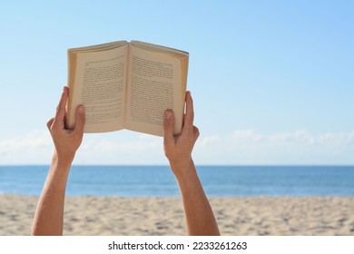 Woman reading book on beach near sea, closeup. Space for text - Powered by Shutterstock