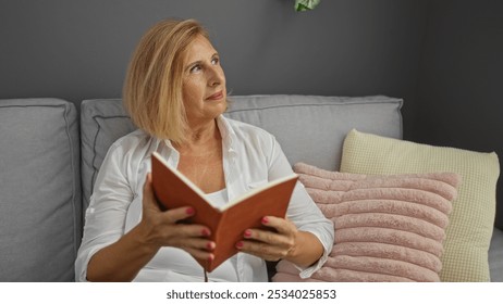 Woman reading book on sofa in living room with cushions, reflecting a serene and cozy indoor setting - Powered by Shutterstock