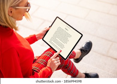 Woman Reading A Book On Tablet. Text On The Screen Is Completely Made Up.