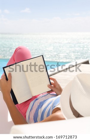 Woman reading book relaxed in deck chair