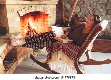 Woman Reading Book And Relaxing By The Fire Place Some Cold Evening, Winter Weekends, Cozy Scene