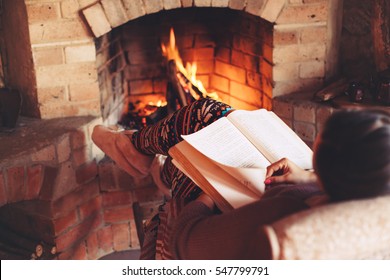 Woman Reading Book And Relaxing By The Fire Place Some Cold Evening, Winter Weekends, Cozy Scene