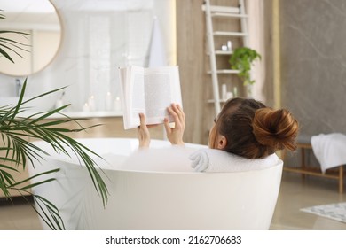 Woman reading book while enjoying bubble bath at home - Powered by Shutterstock