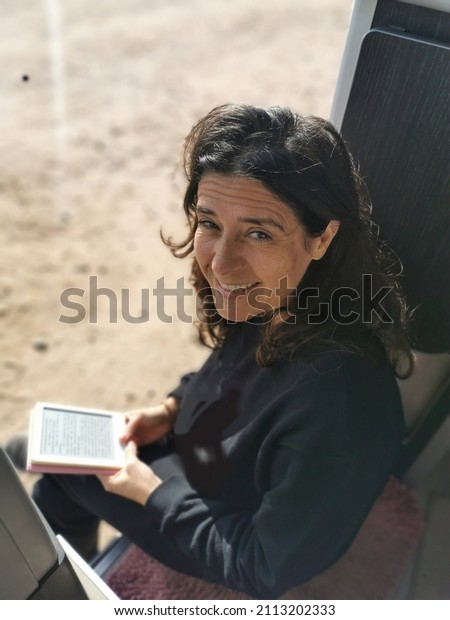 Woman\
reading a happy book in a motorhome at the\
campsite