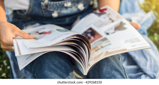 Woman Reading A Magazine Blur In Garden.