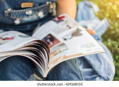 Woman Reading A Magazine Blur In Garden.