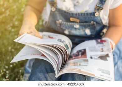 Woman Reading A Magazine Blur In Garden.