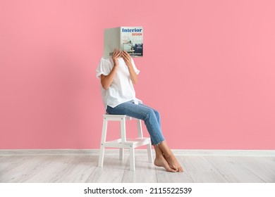 Woman Reading Magazine On White Step Stool Near Pink Wall