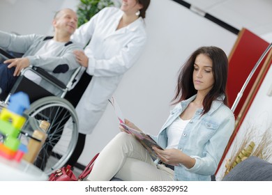 Woman Reading Magazine In The Waiting Room Of A Clinic