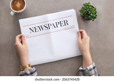 Woman reading morning newspaper at table - Shutterstock ID 2063745428