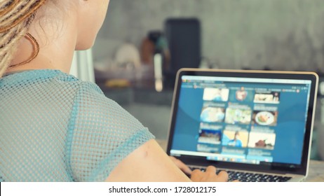 Woman  reading news on a laptop at home. Online Shopping, distance work or online education concept - Shutterstock ID 1728012175