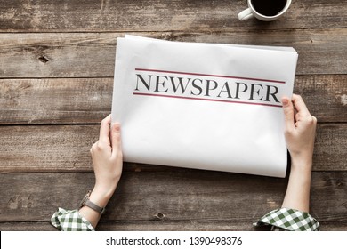 Woman reading newspaper on wooden background - Shutterstock ID 1390498376