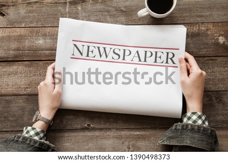 Woman reading newspaper on wooden background