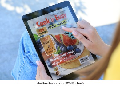 Woman Reading Online Magazine On Tablet Outdoors, Closeup