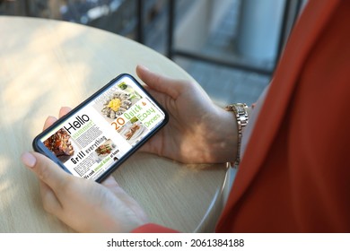 Woman Reading Online Magazine On Smartphone In Outdoor Cafe, Closeup