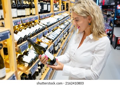 Woman Reading Wine Label At The Store