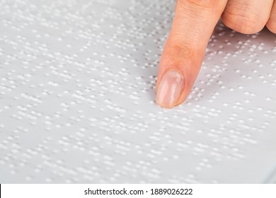 A woman reads a book written in Braille
