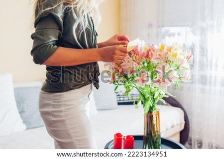 Similar – Woman with peonies on table in the living room