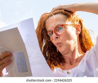 A woman reads a letter with bad news, she reacts emotionally - Shutterstock ID 2196426325