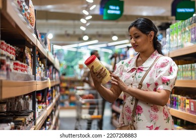 Woman Reads Product Label At Supermarket.