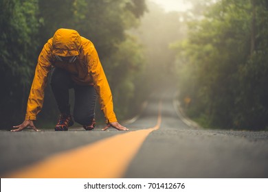 The woman in ready position.  she is running on the long road amidst the beautiful nature. - Shutterstock ID 701412676