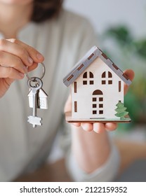 a woman realtor or mortgage agent holds a miniature of the house and keys in her hands. sale and purchase of real estate apartments or houses with a garden. conclusion of a dogvor for the rental of - Shutterstock ID 2122159352