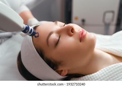 A woman receives laser treatment of the face in a cosmetology clinic, a concept of skin rejuvenation is being developed. laser peeling. - Shutterstock ID 1932710240