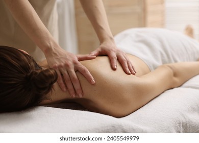 Woman receiving back massage on couch in spa salon - Powered by Shutterstock