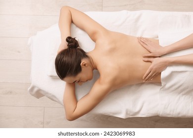 Woman receiving back massage on couch in spa salon, top view - Powered by Shutterstock