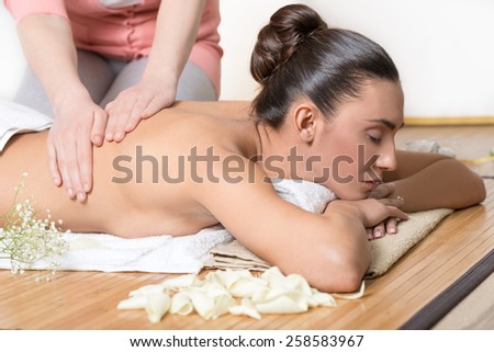 Woman Receiving Back Massage in Spa Center