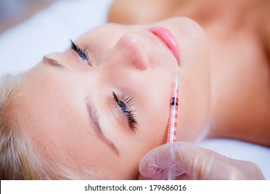 Woman Receiving A Botox Injection In Her Lips, Close Up