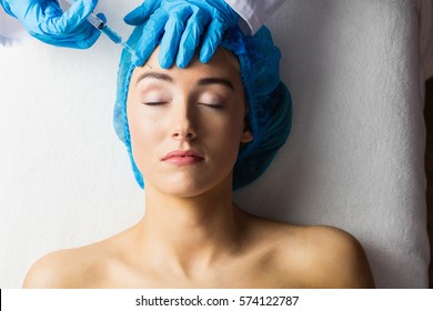 Woman Receiving Botox Injection On Her Forehead In Examination Room