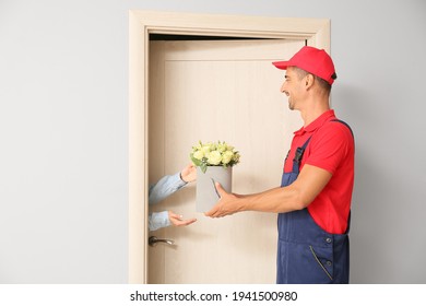 Woman Receiving Bouquet Of Flowers From Courier