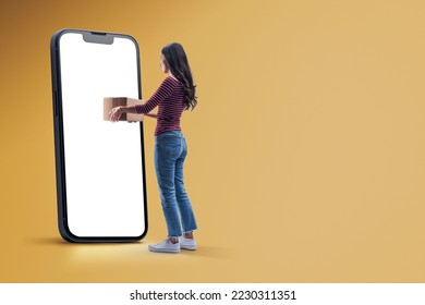 Woman receiving a box from her smartphone, online express delivery service and online shopping concept - Powered by Shutterstock