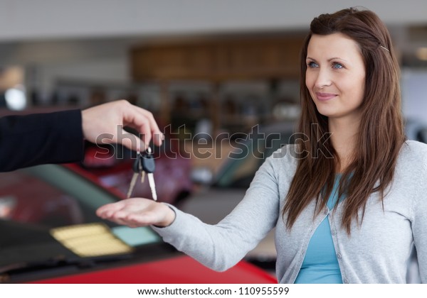 Woman\
receiving car keys in his hand in a\
garage