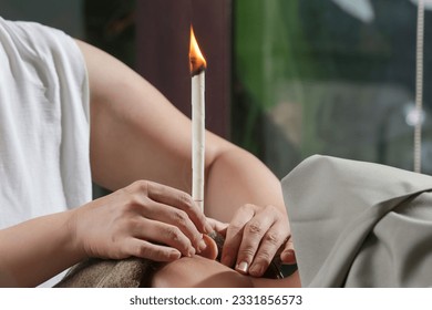 Woman receiving ear candle treatment at spa. Ear coning or thermal-auricular therapy.	 - Powered by Shutterstock