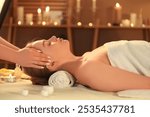 Woman receiving face massage in spa salon